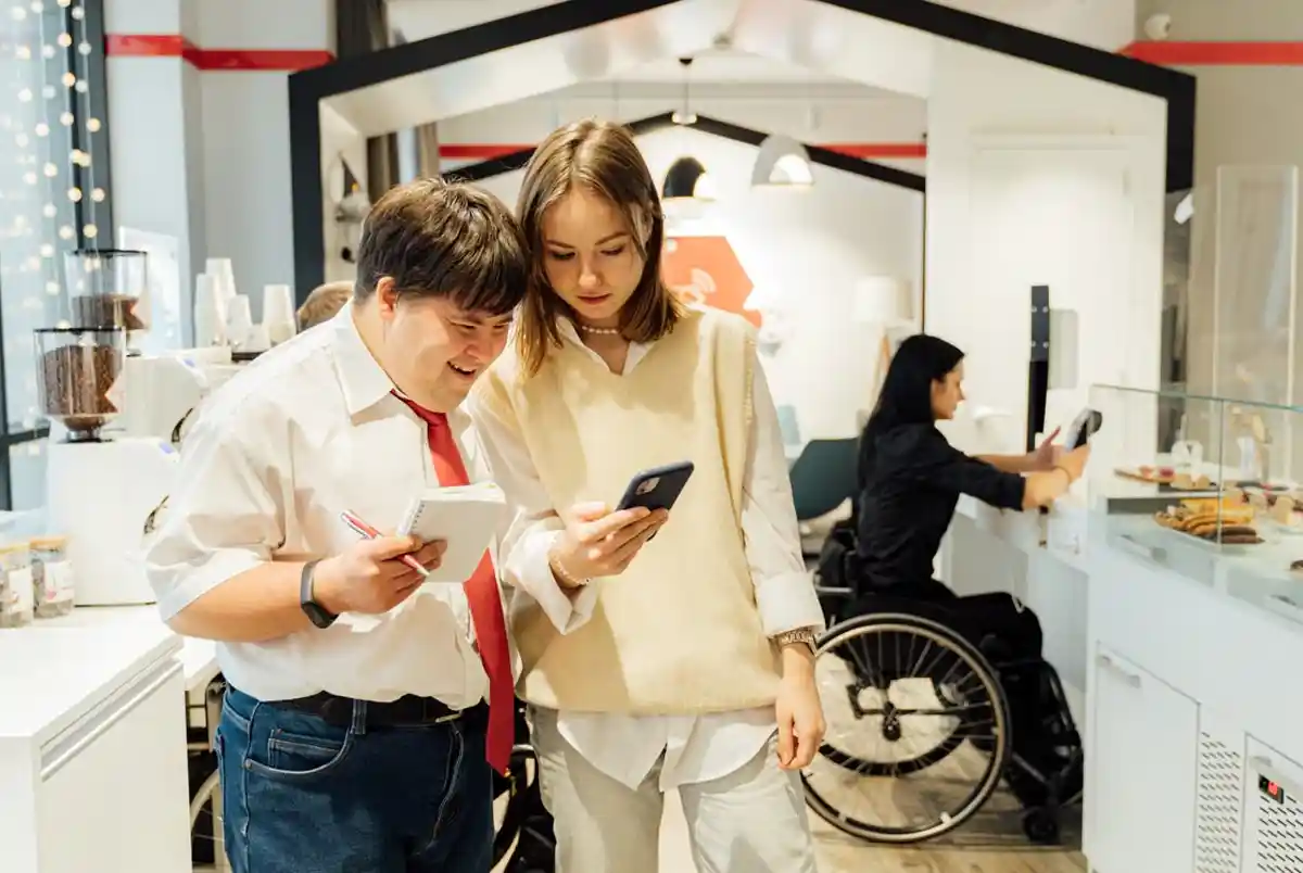 A person filling out an application form with the help of a support worker